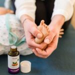 Babymassage und Babyyoga - der Fuß eines Babies wird massiert - Stärke die Beziehung und Bindung zu deinem Baby. Plus: Unterschiedliche Techniken für spezielle Themen wie Koliken, Zahnen, Sichelfüße, o.Ä.